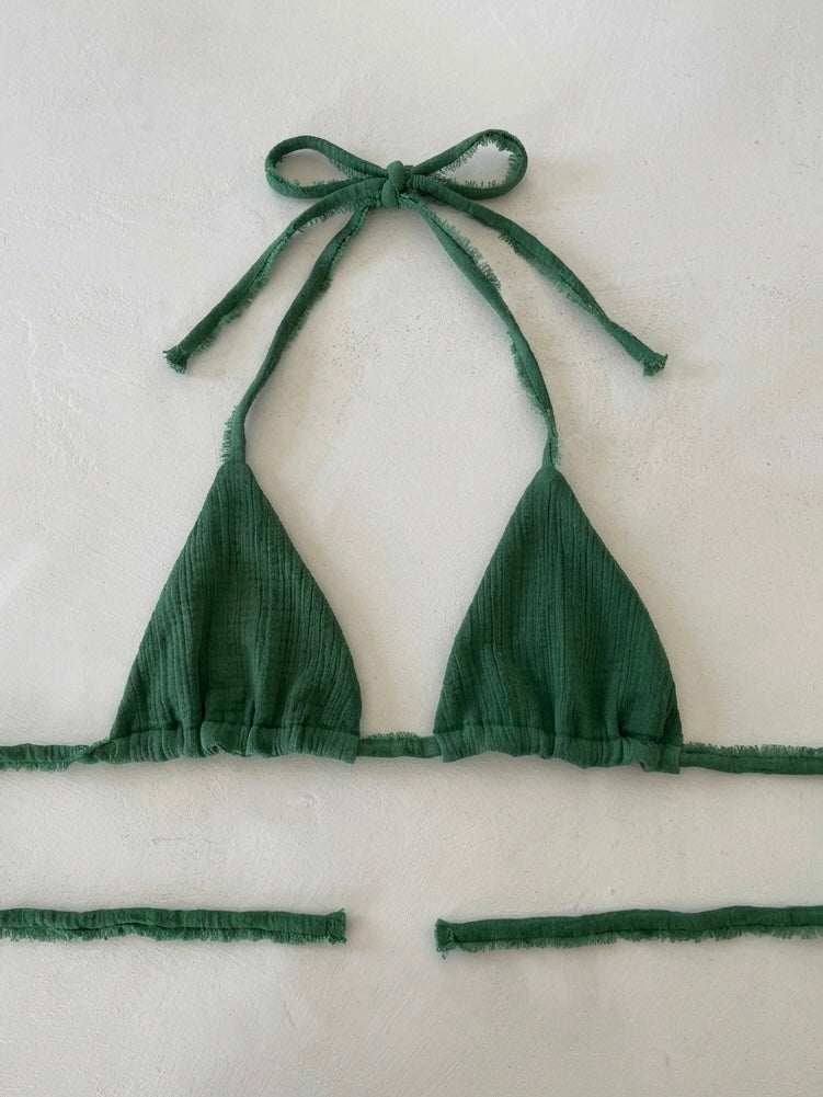 Green bikini top with tie straps on a white background